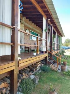 une terrasse couverte d'une maison avec une terrasse en bois dans l'établissement Abrazados Suites del Valle, à Villa Yacanto