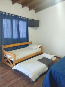 two twin beds in a room with a window at Abrazados Suites del Valle in Villa Yacanto