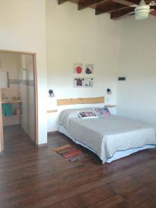 - une chambre avec un lit et du parquet dans l'établissement Abrazados Suites del Valle, à Villa Yacanto