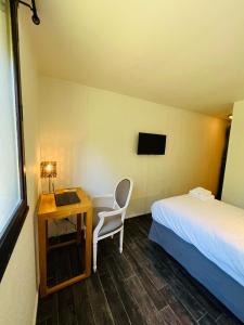 Cette chambre comprend un lit et un bureau avec une chaise. dans l'établissement Hôtel Le Forestia, à Pannes