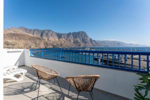 a balcony with chairs and a view of the mountains at Agaete White&Blue Rooftop in Agaete