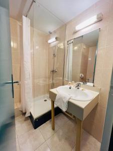 La salle de bains est pourvue d'un lavabo et d'une douche. dans l'établissement Hôtel Le Forestia, à Pannes