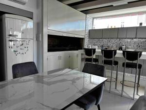 cocina con mesa de mármol y sillas en Center Suites Apartamento super fantastico POR MES!! en La Plata