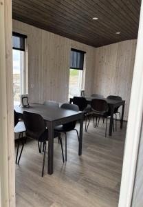 a group of tables and chairs in a room at Strönd Guesthouse in Birkimelur 