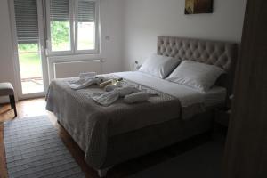 a bedroom with a large bed with towels on it at Apartmani Ramonda in Teslić