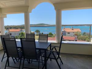 d'une table et de chaises sur un balcon avec vue sur l'eau. dans l'établissement Villa Livi - Luxury sea view appartments, à Medulin
