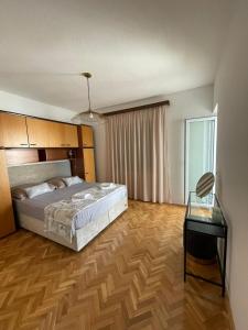 a bedroom with a large bed and a table at Apartment Capitano in Slatine