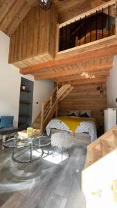 a bedroom with a loft with a bed and a table at CHAMBRES D'HÔTES LES CHAMBRES D'ELSA in Albiez-Montrond