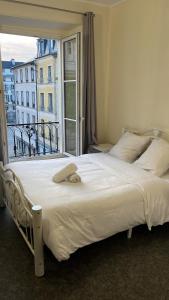 sypialnia z dużym łóżkiem i dużym oknem w obiekcie L’ESPERANCE w Wersalu