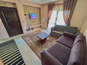 uma sala de estar com um sofá e uma televisão em Two Bedroom at Sunny Lakes Resort em Sharm el Sheikh