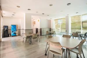 een cafetaria met tafels en stoelen in een gebouw bij Casa Claire in Cala de Finestrat