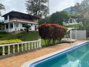 コパカバーナにあるFinca Villa Conie (Los Leones)の家の前にスイミングプールがある家
