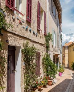 un callejón en una casa vieja con persianas rojas en Appartement le Quai du Port Cassis parking clim en Cassis