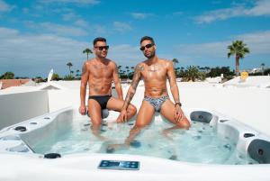 two men are sitting in a hot tub at MAR BIANCO - Gay Men Only in Maspalomas