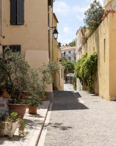 an alley in an old town with potted plants at Appartement le Quai du Port Cassis parking clim in Cassis