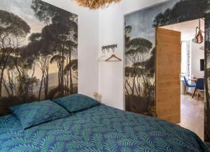 a bedroom with a bed and a painting on the wall at Appartement le Quai du Port Cassis parking clim in Cassis