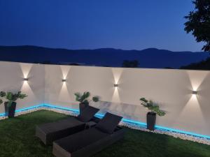 a backyard with two couches and a wall with lights at Istočno Sarajevo in Sarajevo