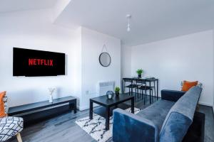 a living room with a blue couch and a tv at Beautiful apartment DOS in Litherland