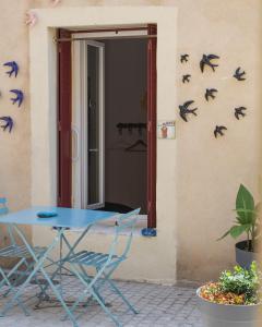 a blue table and chairs in front of a wall with birds at Appartement le Quai du Port Cassis parking clim in Cassis