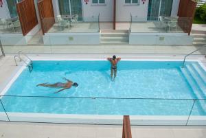 2 personas nadando en una gran piscina en MAR BIANCO - Gay Men Only en Maspalomas