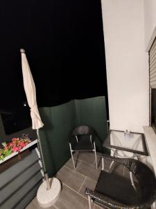 een kamer met een tafel, een stoel en een paraplu bij FeWo3&Frisch renovierte Wohnung mit Balkon in Bad Wurzach