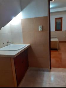 baño con lavabo y habitación con cama en Departamento Celsa en Salta