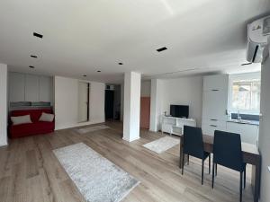 a white living room with a table and chairs at Studio Y in Gjakove