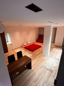 a bedroom with a red bed and a table at Studio Y in Gjakove