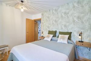 1 dormitorio con 1 cama blanca grande y 2 almohadas en El rincón de Julia, en Salamanca