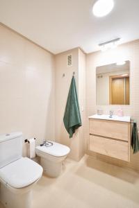 a bathroom with a white toilet and a sink at El rincón de Julia in Salamanca