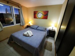 a bedroom with a bed with two towels on it at Portal Sureño in Dina Huapi