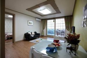 a living room with a table and a couch at Capri Hakdong Pension in Geoje 