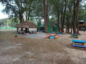 un parque infantil con bancos coloridos y una cabaña en Green Park, en Punta del Este