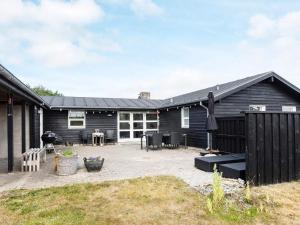 una casa negra con un patio delante en Two-Bedroom Holiday home in Løkken 20, en Løkken