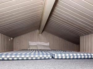 ロッケンにあるTwo-Bedroom Holiday home in Løkken 20の木製の天井の客室のベッド1台分です。