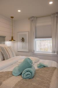 ein Bett mit zwei Handtüchern und einem Fenster in der Unterkunft Inspire Beach 3 Total Cabins - Beachfront and Waterfront -Hot Tubs & Sauna in Kawartha Lakes