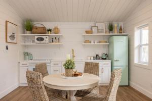 eine Küche mit einem Tisch und Stühlen sowie einem Kühlschrank in der Unterkunft Inspire Beach 3 Total Cabins - Beachfront and Waterfront -Hot Tubs & Sauna in Kawartha Lakes