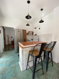 cocina con encimera de madera y 2 sillas en Casita del Artista, en San Patricio Melaque