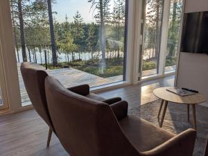 a living room with two chairs and a large window at Lakehouse Juolas in Mäntyharju