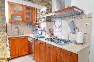 une cuisine avec des armoires en bois et un four à plaques de cuisson dans l'établissement Apartment OAZA, à Kotor 21 autres photos