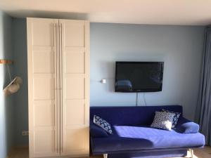 uma sala de estar com um sofá azul e uma televisão em CASA QUARTO - Vacation Home - 4 Appartements em Omiš