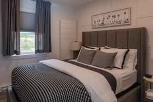 ein Schlafzimmer mit einem großen Bett und einem Fenster in der Unterkunft Inspire Beach 3 Total Cabins - Beachfront and Waterfront -Hot Tubs & Sauna in Kawartha Lakes