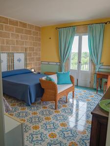 - une chambre avec un lit, une chaise et des fenêtres dans l'établissement Agriturismo Masseria Alcorico, à Gagliano del Capo
