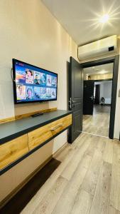 ArsinにあるRosella Royal Suit - روزيلا رويالの壁に大画面薄型テレビが備わる客室です。