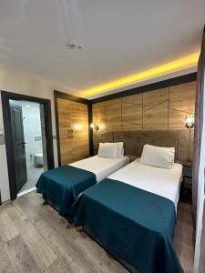 ArsinにあるRosella Royal Suit - روزيلا رويالのベッド2台とバスルームが備わるホテルルームです。