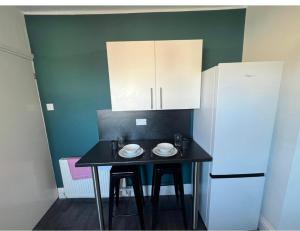 uma pequena cozinha com uma mesa e um frigorífico em Spacious 2bedroom property by Star Suites em Elswick