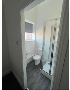 a bathroom with a toilet and a glass shower at Spacious 2bedroom property by Star Suites in Elswick