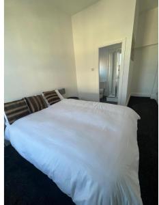 um quarto com uma grande cama branca num quarto em Spacious 2bedroom property by Star Suites em Elswick