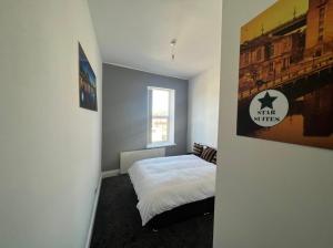 a small bedroom with a bed and a window at Spacious 2bedroom property by Star Suites in Elswick