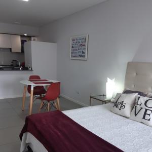 um quarto com uma cama, uma mesa e uma cozinha em Loft Dorrego Rio em Rosário